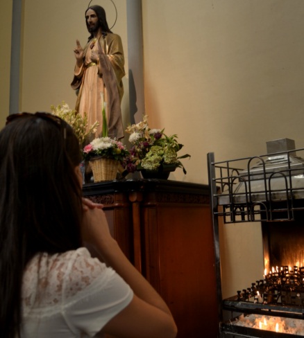 Jessica Pacheco Novicki em oração diante da imagem de Jesus — fé e propósito na trajetória da fundadora da ZAYA Boutique, Curitiba